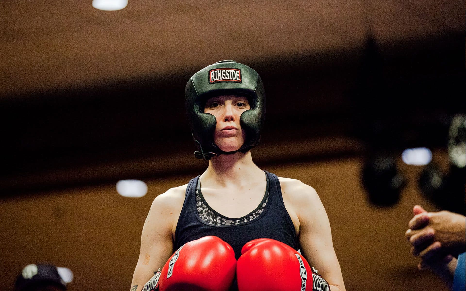 A Golden Gloves boxer in headgear waits in the corner