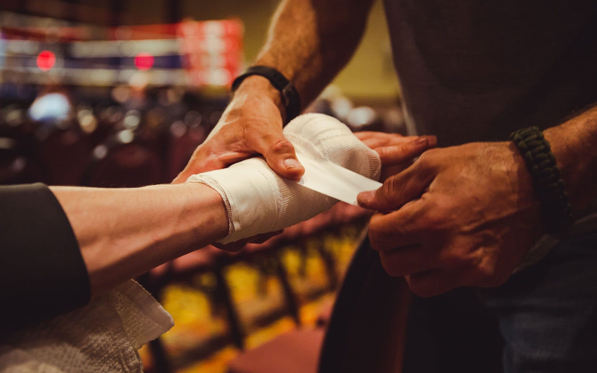 A coach wraps a boxer's hands before a bout
